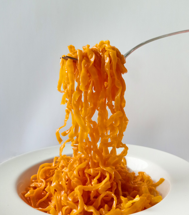 cooked roasted bell pepper linguine pasta in a white plate เส้นพาสต้าลิงกวินีสดผสมพริกหวานย่างลวกสุก