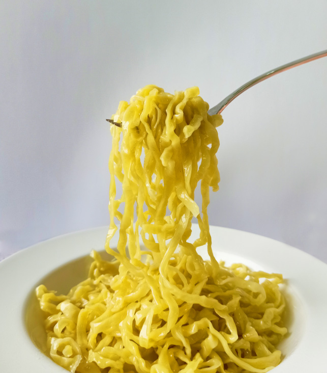 cooked free-ranged egg linguine pasta in a white plate เส้นพาสต้าลิงกวินีสดจากไข่แม่ไก่อารมณ์ดีลวกสุก